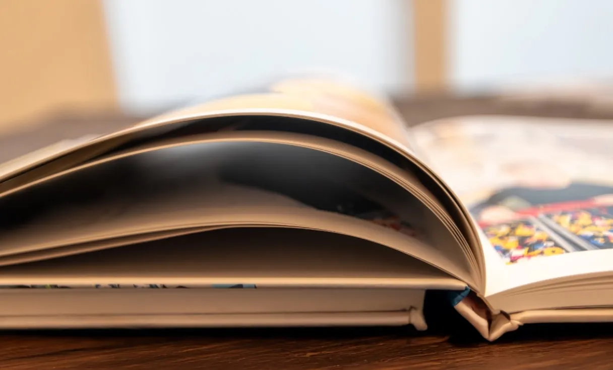 Photo book pages fanned open showing the quality of premium paper and printing